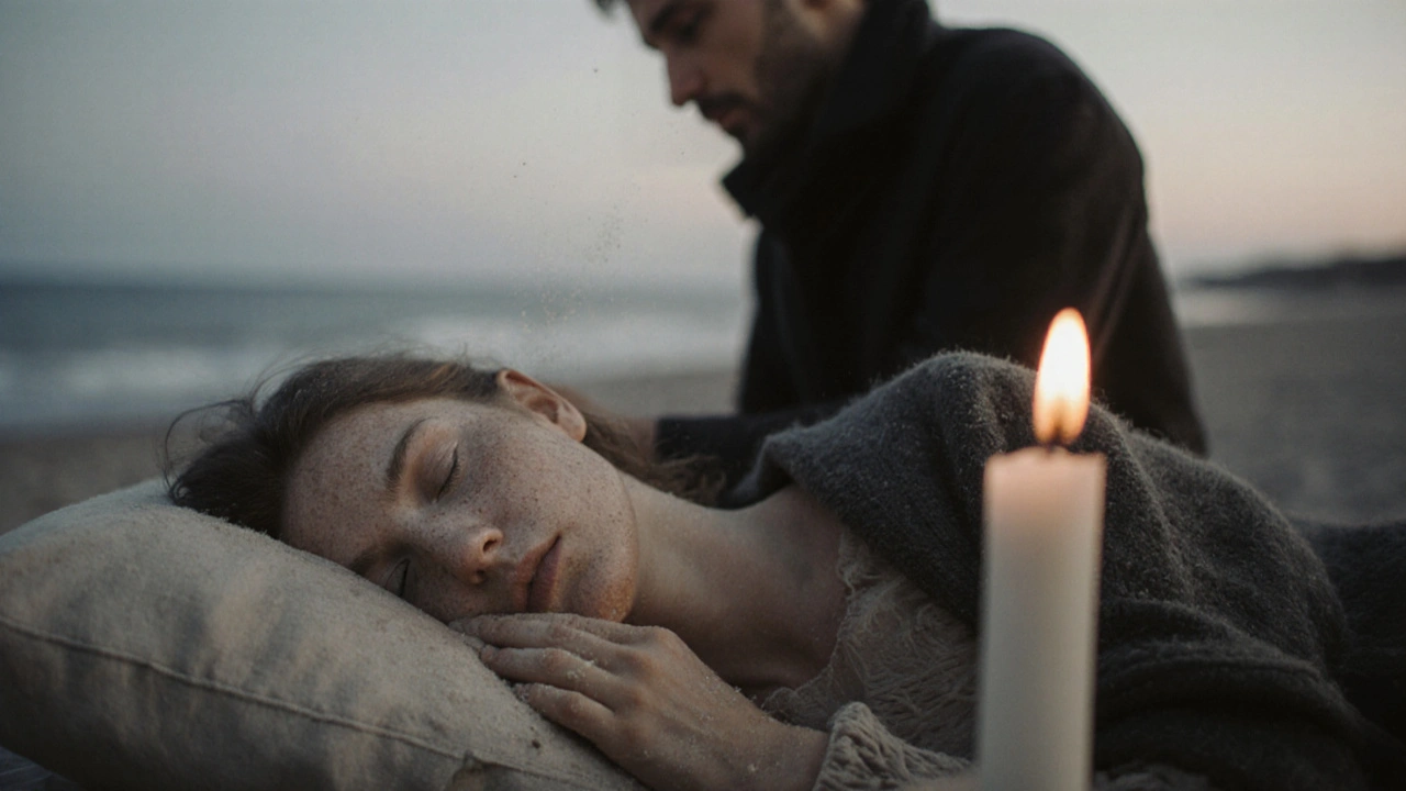 Een vrouw slaapt op het strand met zand op haar gezicht, een man kijkt naar haar terwijl een kaars nog brandt.