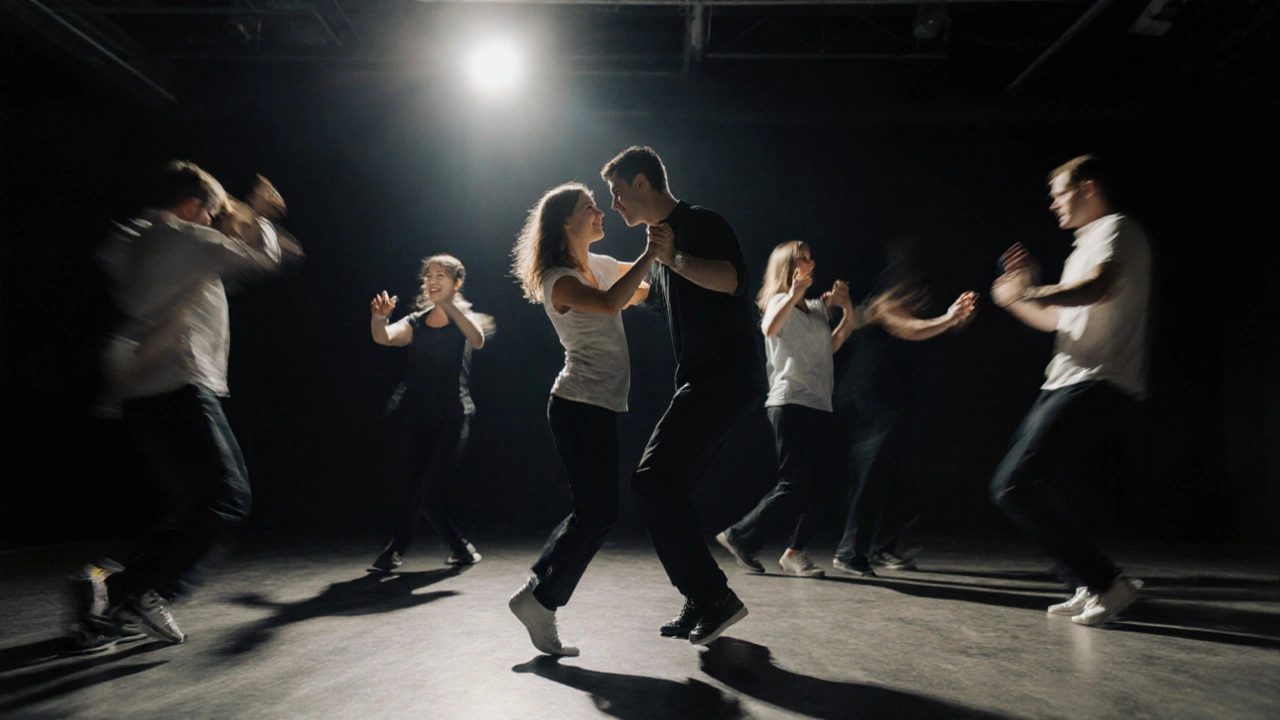 Een man en een vrouw dansen in een studio, ogen op elkaar gericht, anderen in de achtergrond in beweging.