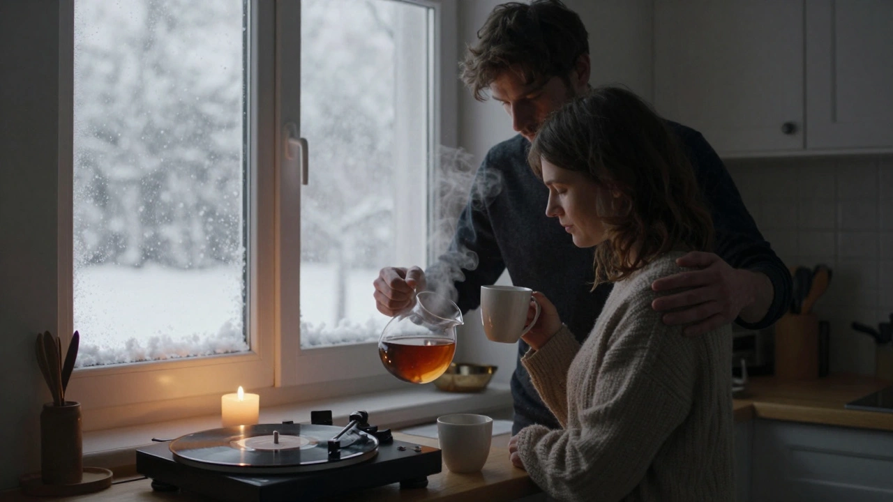 Een man staat achter zijn partner in de keuken, terwijl ze thee zet — een moment van stilte en verbinding.