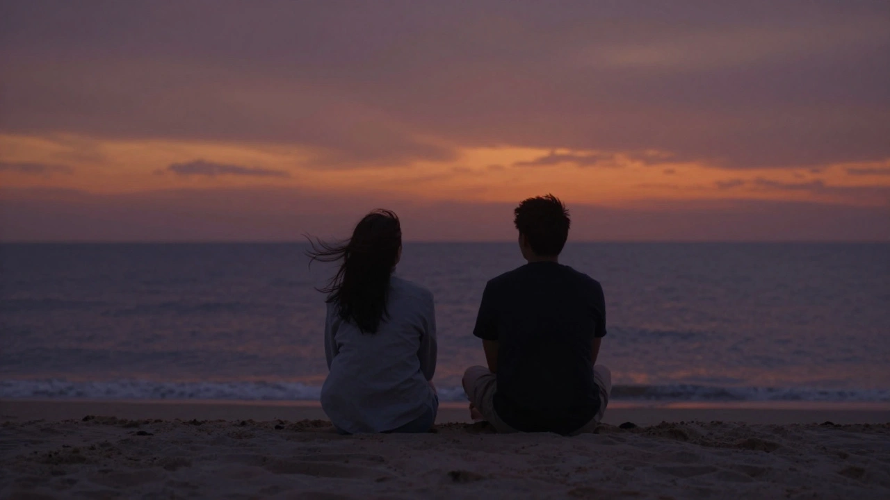 Een man en vrouw zitten stilletjes op het strand bij zonsondergang, zonder apparaten, alleen wind en zand.